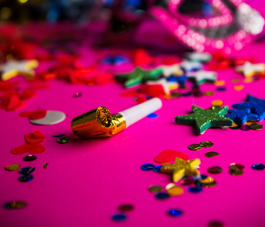 Chão cor de rosa choque coberto por confeti, estrelas e outros itens de folia de carnaval